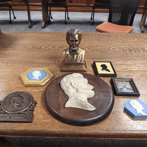 Several artifacts commemorating or recognizing Abraham Lincoln, including a small bronze bust of Abraham Lincoln.